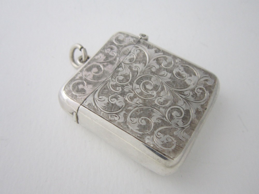 An antique sterling silver vesta case featuring hand-engraved foliate scrollwork, a vacant shield cartouche, and an attached suspension ring. View III