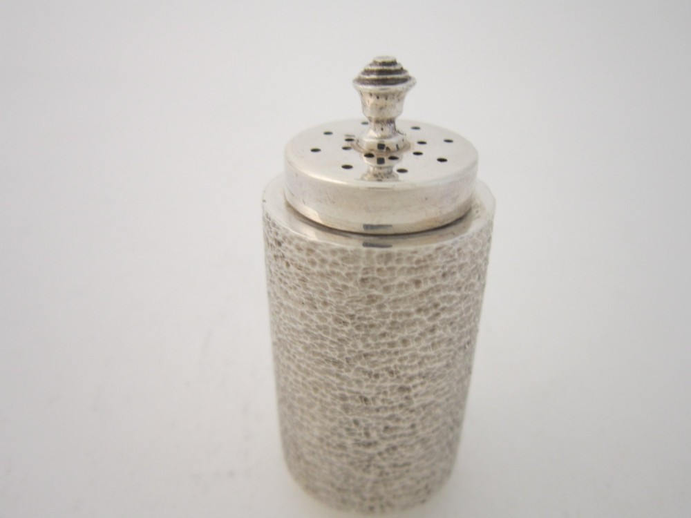 A three-piece sterling silver condiment set with textured bark-effect surfaces including a salt cellar, mustard pot, pepper shaker, and two spoons in a blue fitted case. View VI