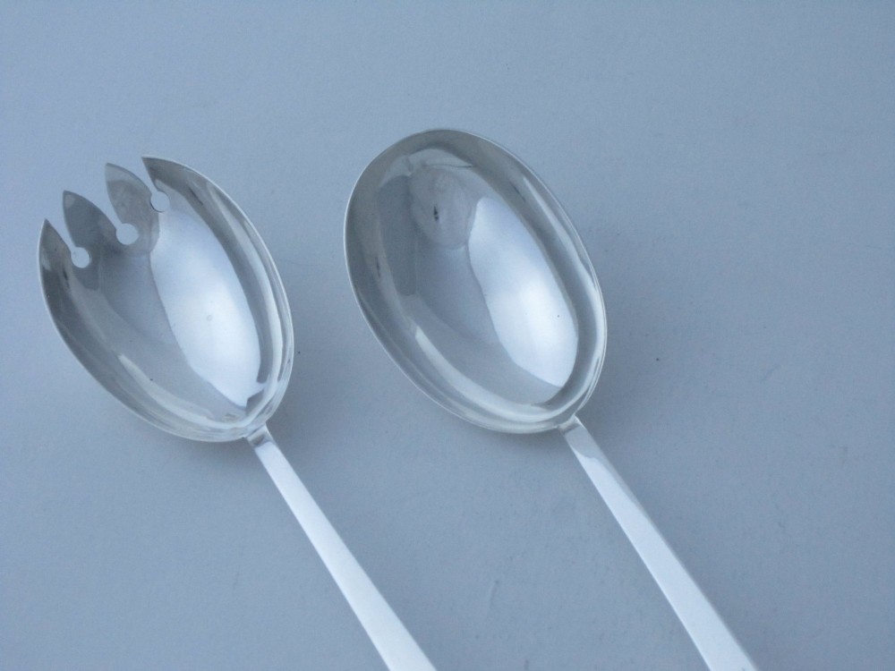 A pair of Edwardian sterling silver salad servers featuring faceted cut glass handles and rat tail detailing on the bowls. View II