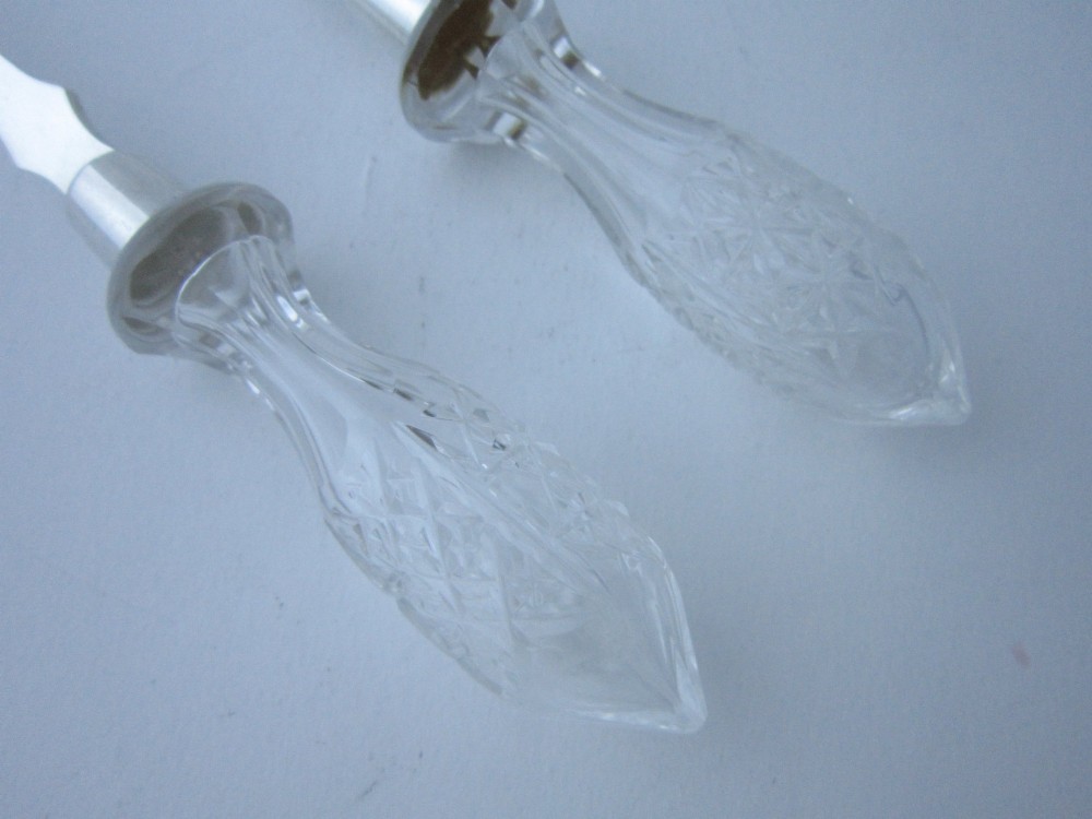 A pair of Edwardian sterling silver salad servers featuring faceted cut glass handles and rat tail detailing on the bowls. View III
