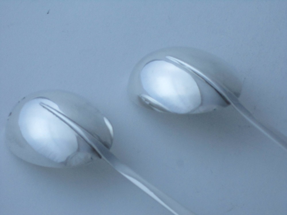 A pair of Edwardian sterling silver salad servers featuring faceted cut glass handles and rat tail detailing on the bowls. View V