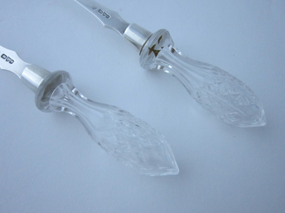 A pair of Edwardian sterling silver salad servers featuring faceted cut glass handles and rat tail detailing on the bowls. View VI