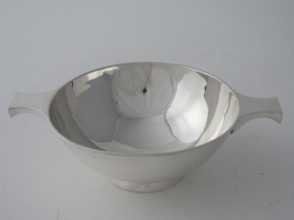 A polished sterling silver Scottish quaich featuring a shallow circular bowl, raised foot, and twin flat handles. View II