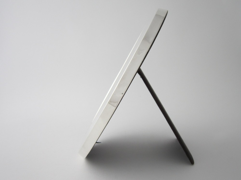 An oval sterling silver photograph frame featuring a smooth, polished border. View III