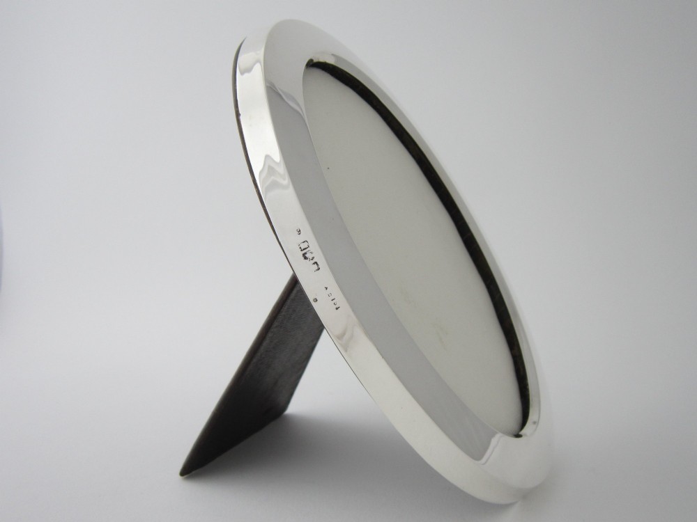 An oval sterling silver photograph frame featuring a smooth, polished border. View V