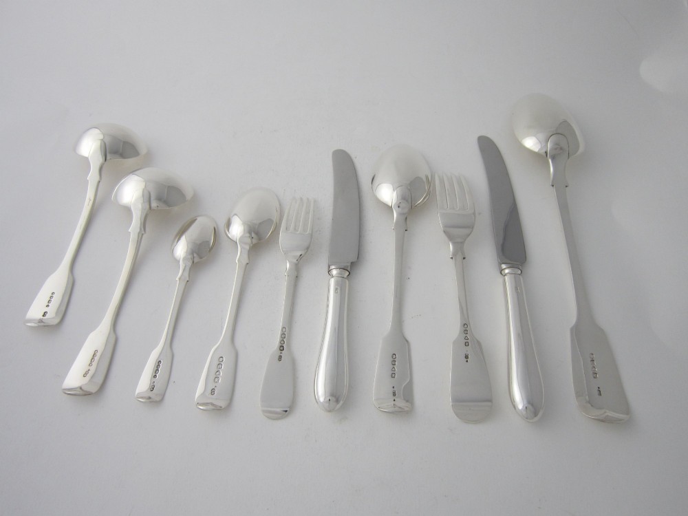 An open wooden canteen box lined with blue fabric displaying a complete set of Victorian sterling silver fiddle pattern cutlery. View VI