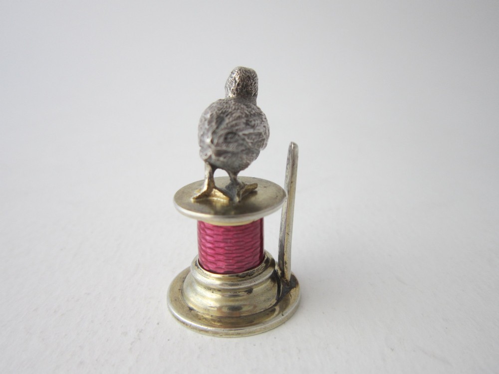 A set of four Edwardian sterling silver place card holders featuring pink guilloche enamel columns topped with sculpted game birds inside a fitted presentation box. View IV