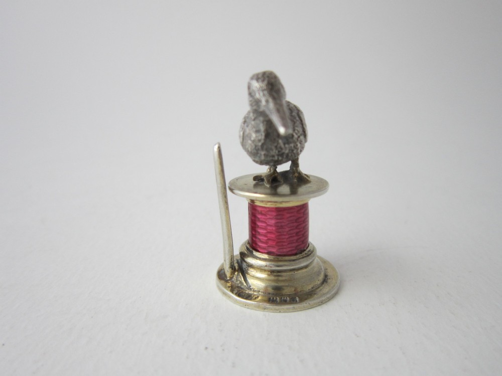 A set of four Edwardian sterling silver place card holders featuring pink guilloche enamel columns topped with sculpted game birds inside a fitted presentation box. View VI