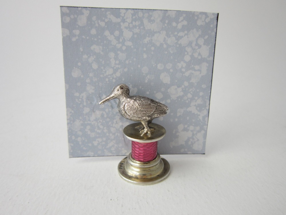 A set of four Edwardian sterling silver place card holders featuring pink guilloche enamel columns topped with sculpted game birds inside a fitted presentation box. View VII