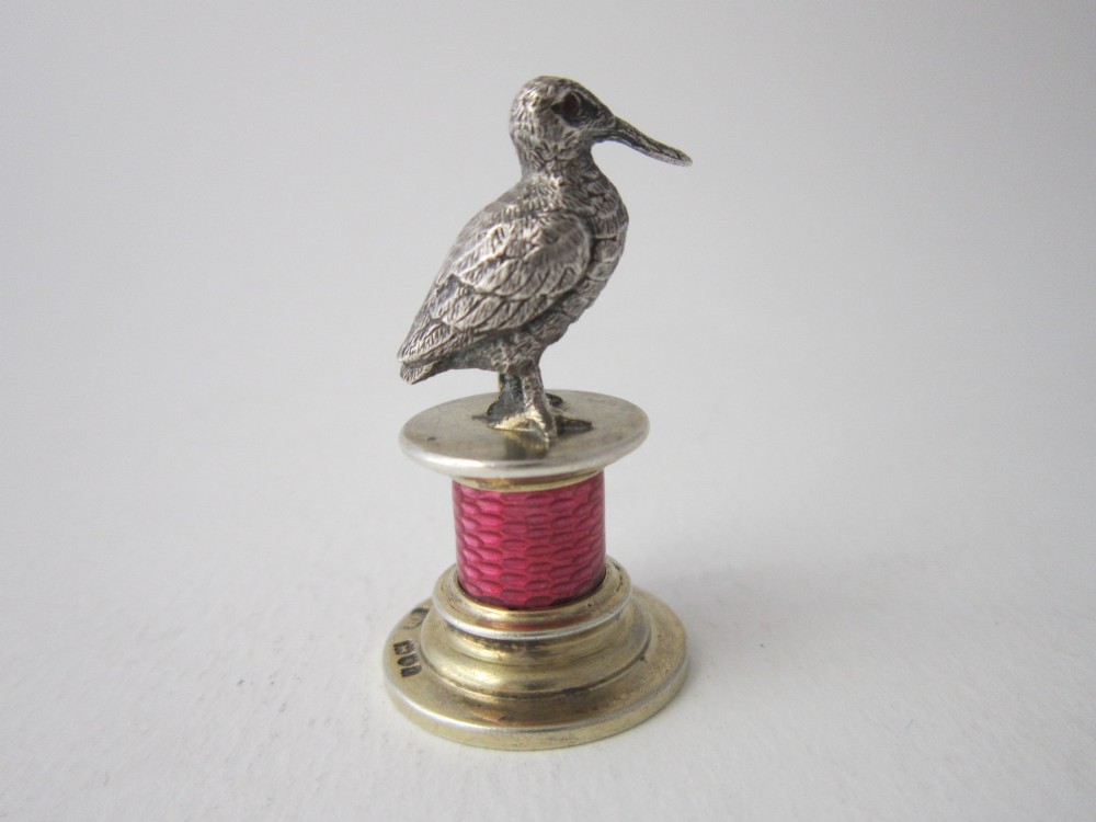 A set of four Edwardian sterling silver place card holders featuring pink guilloche enamel columns topped with sculpted game birds inside a fitted presentation box. View XI
