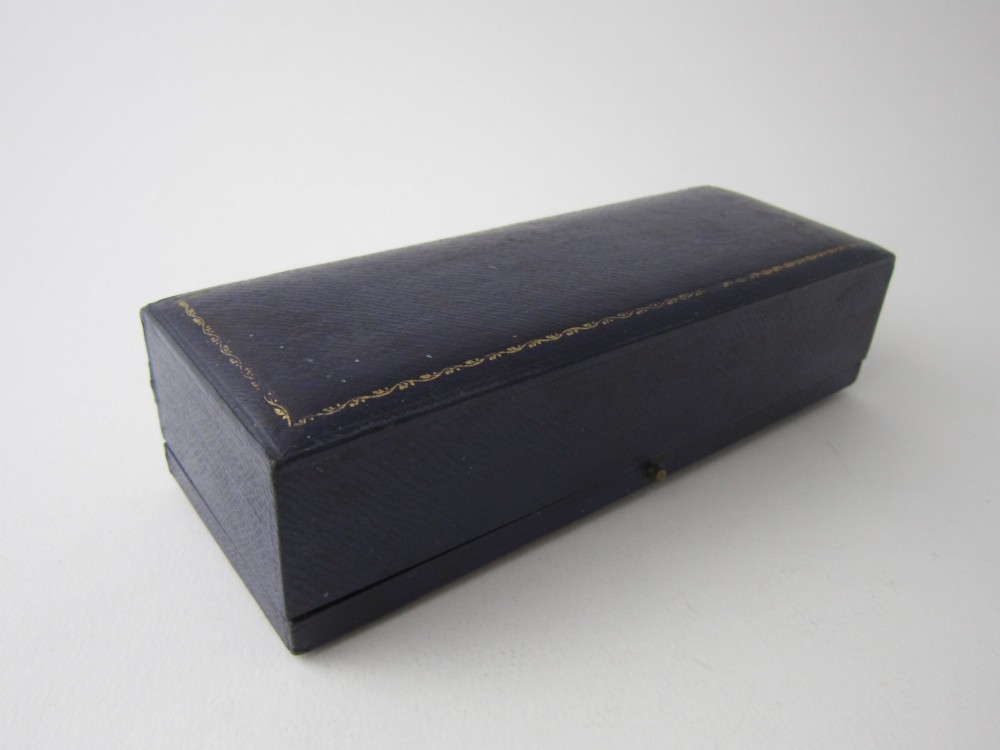 A pair of hallmarked sterling silver asparagus serving tongs with slotted blades resting inside a fitted presentation case. View II