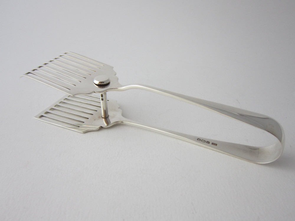 A pair of hallmarked sterling silver asparagus serving tongs with slotted blades resting inside a fitted presentation case. View III