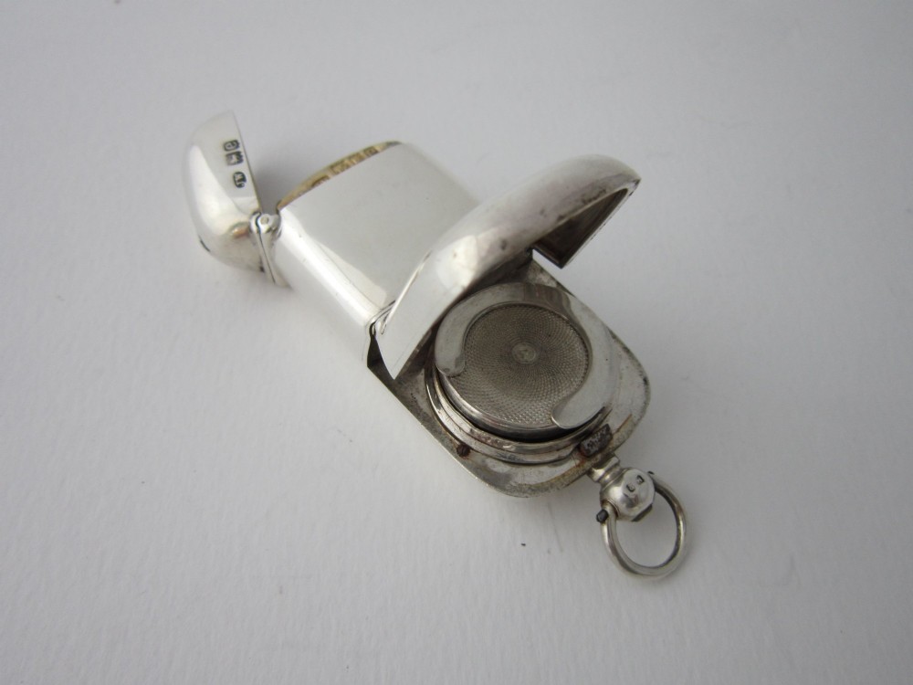A late Victorian hallmarked sterling silver combination sovereign holder and vesta case shown open, featuring a spring-loaded coin mechanism and top suspension loop.