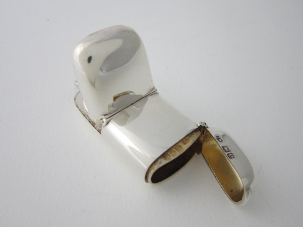 A late Victorian hallmarked sterling silver combination sovereign holder and vesta case shown open, featuring a spring-loaded coin mechanism and top suspension loop. View II