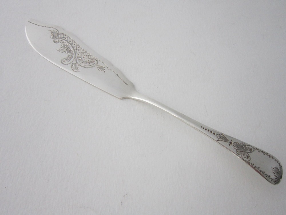 An Edwardian sterling silver butter knife with engraved scrollwork and foliate details on the blade and handle.