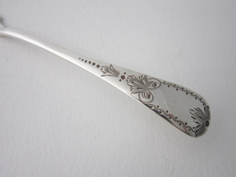 An Edwardian sterling silver butter knife with engraved scrollwork and foliate details on the blade and handle. View III