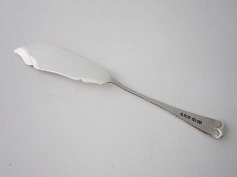 An Edwardian sterling silver butter knife with engraved scrollwork and foliate details on the blade and handle. View IV