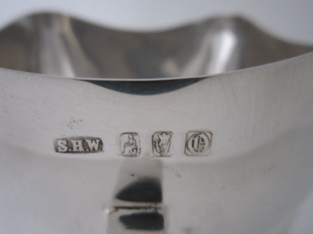 An Edwardian sterling silver mether cup featuring a square mouth and four angular handles that extend downward to form the feet. View VI
