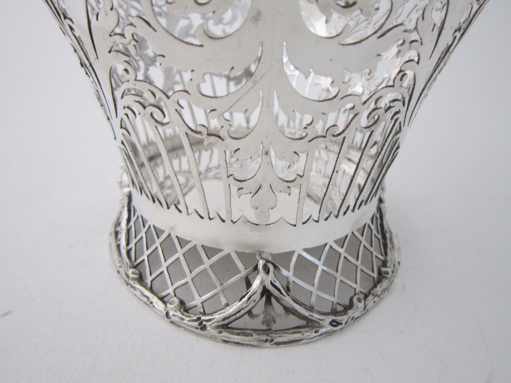 An antique George V sterling silver basket featuring intricate pierced lattice metalwork, scrolled grapevine borders, and visible hallmarks. View IX