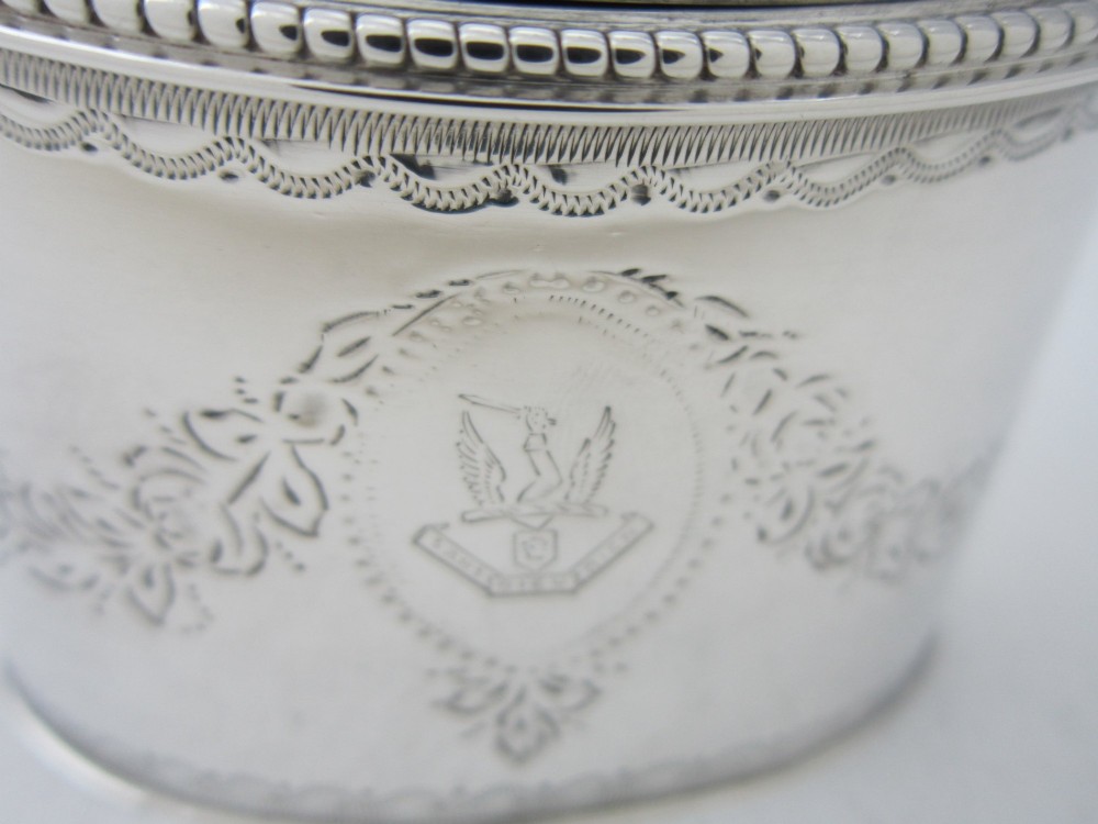 An oval sterling silver mustard pot featuring bright-cut engraved patterns, a beaded rim, a scroll handle, and a matching spoon. View VIII
