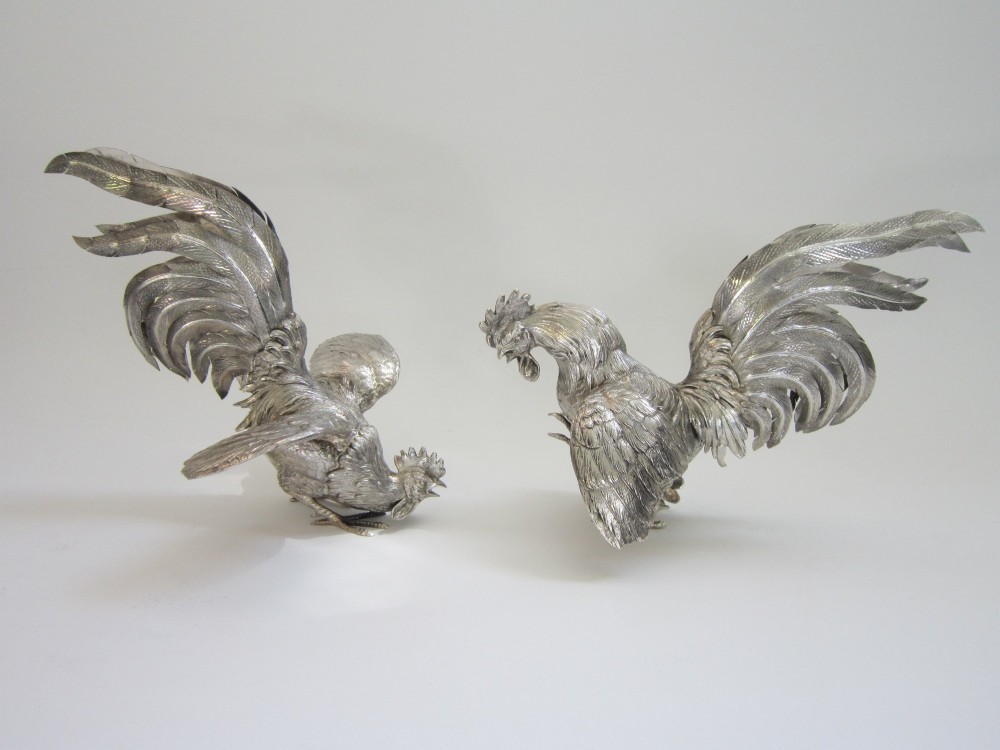 A pair of detailed sterling silver figures depicting fighting cockerels with open wings and realistic feather textures. View II