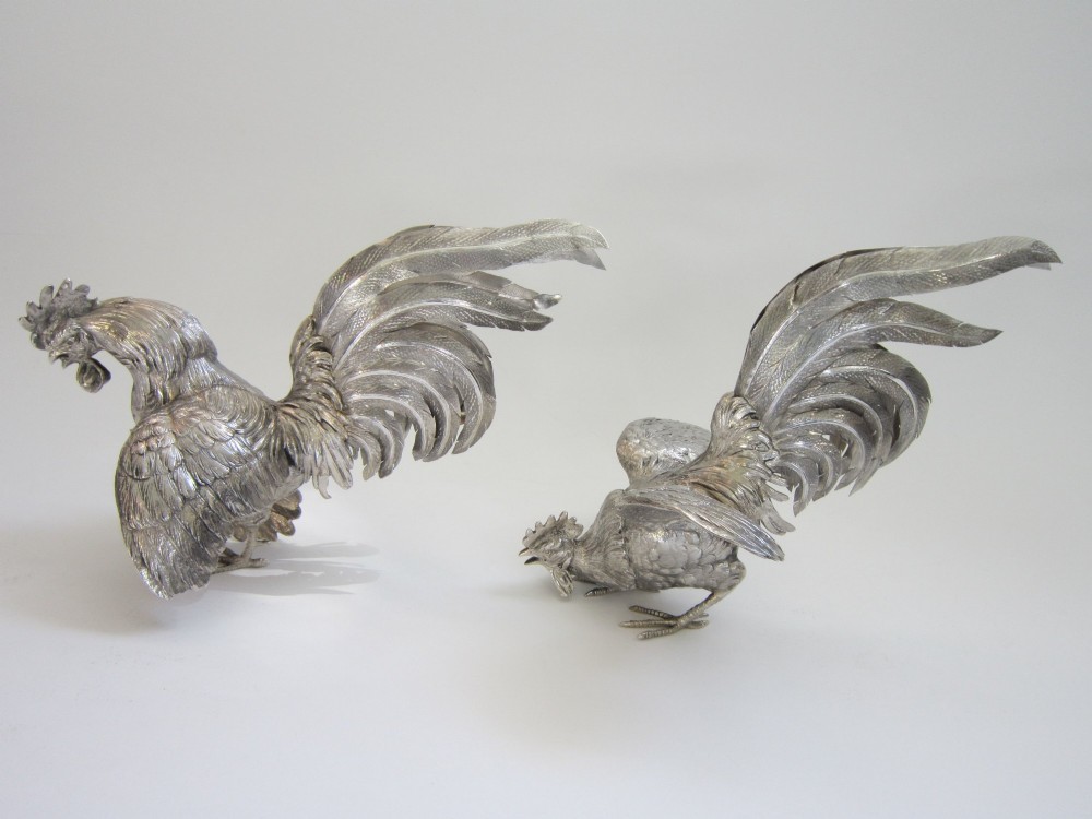 A pair of detailed sterling silver figures depicting fighting cockerels with open wings and realistic feather textures. View III