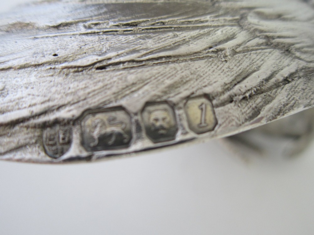 A pair of detailed sterling silver figures depicting fighting cockerels with open wings and realistic feather textures. View IX