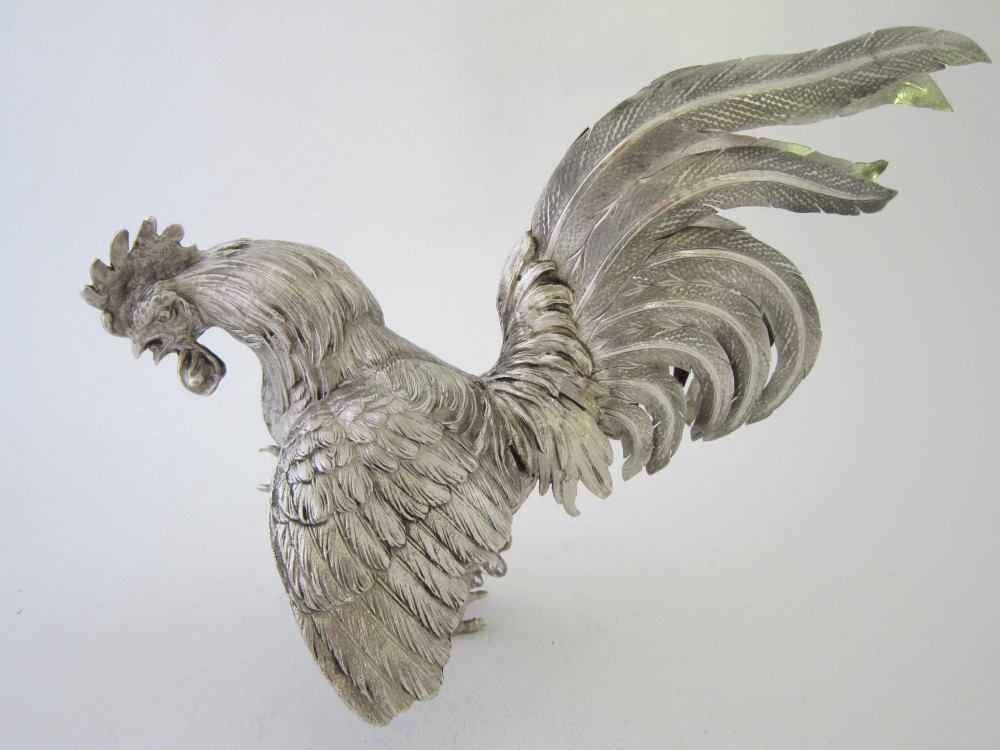 A pair of detailed sterling silver figures depicting fighting cockerels with open wings and realistic feather textures. View XI