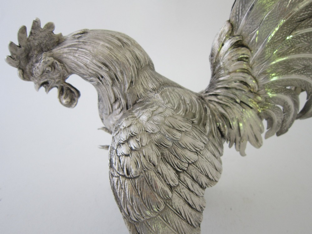 A pair of detailed sterling silver figures depicting fighting cockerels with open wings and realistic feather textures. View XIV