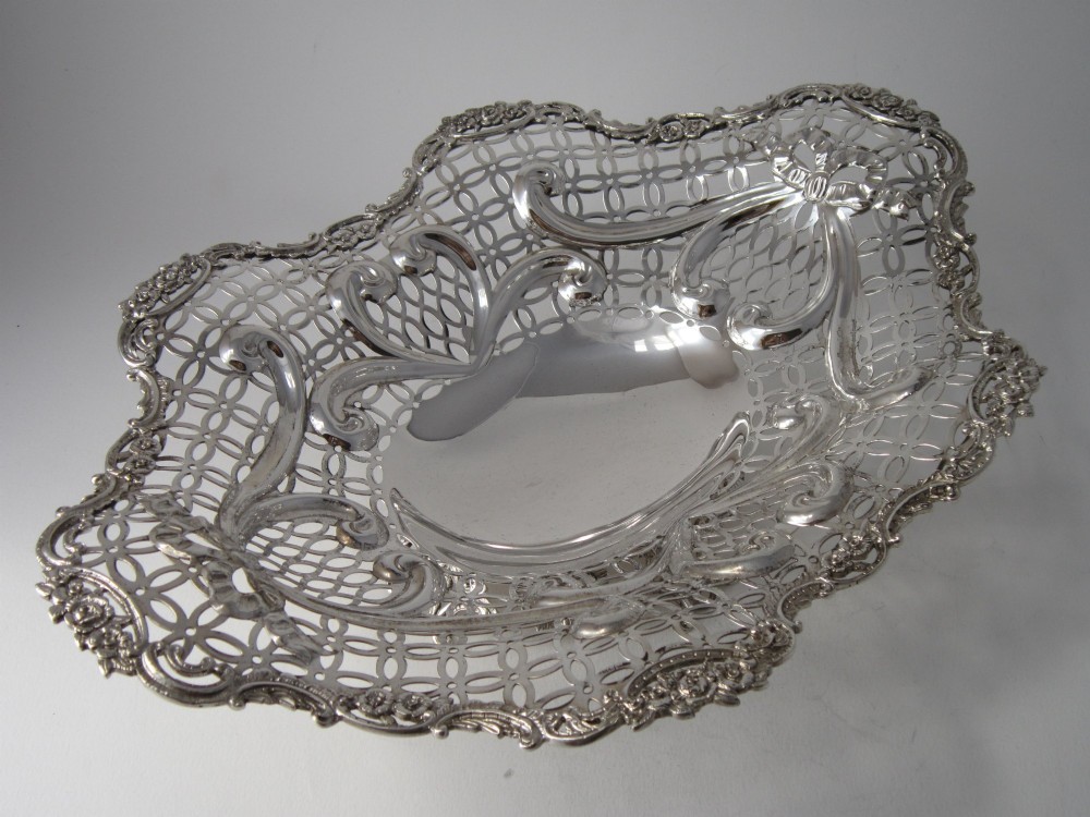 A pair of late Victorian sterling silver dishes featuring intricate pierced lattice pattern, ornate scroll borders, and raised feet. View IV