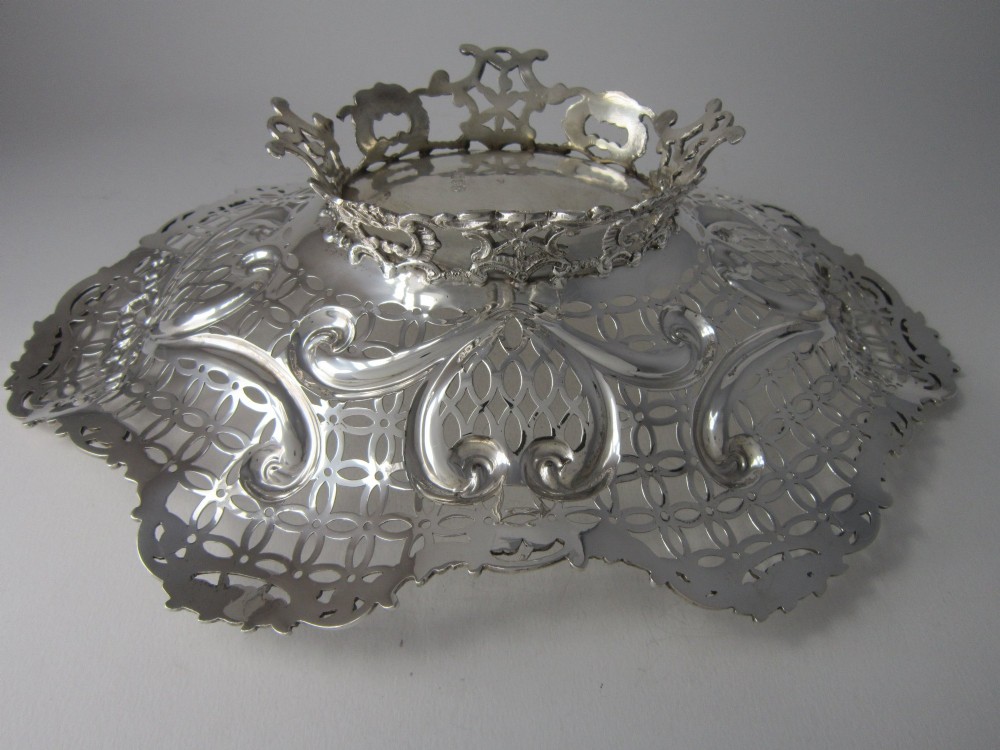A pair of late Victorian sterling silver dishes featuring intricate pierced lattice pattern, ornate scroll borders, and raised feet. View VII