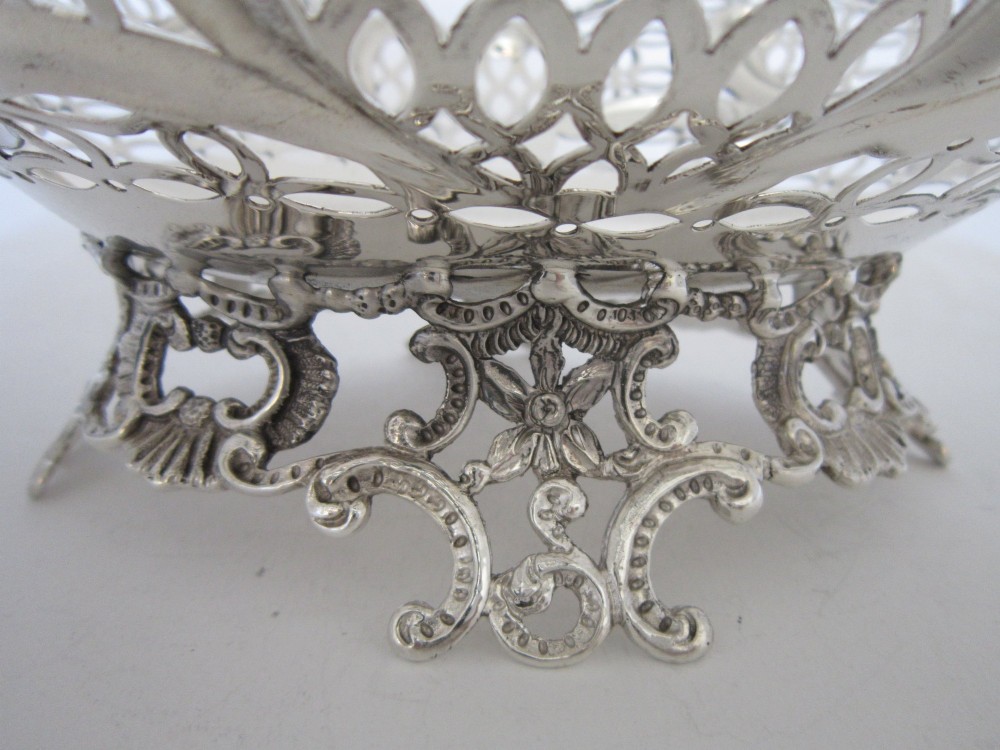 A pair of late Victorian sterling silver dishes featuring intricate pierced lattice pattern, ornate scroll borders, and raised feet. View VIII