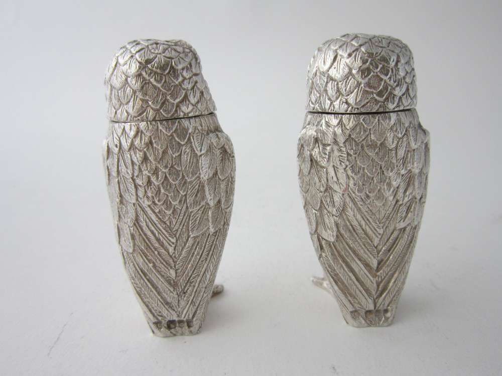 A pair of cast sterling silver salt and pepper shakers in the form of standing owls with textured feather detailing and dark amber glass eyes. View III