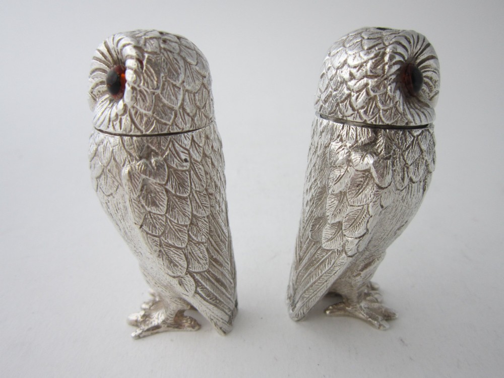 A pair of cast sterling silver salt and pepper shakers in the form of standing owls with textured feather detailing and dark amber glass eyes. View VI