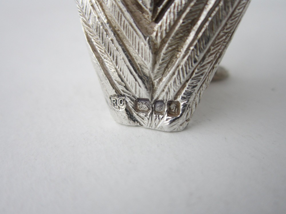 A pair of cast sterling silver salt and pepper shakers in the form of standing owls with textured feather detailing and dark amber glass eyes. View VII