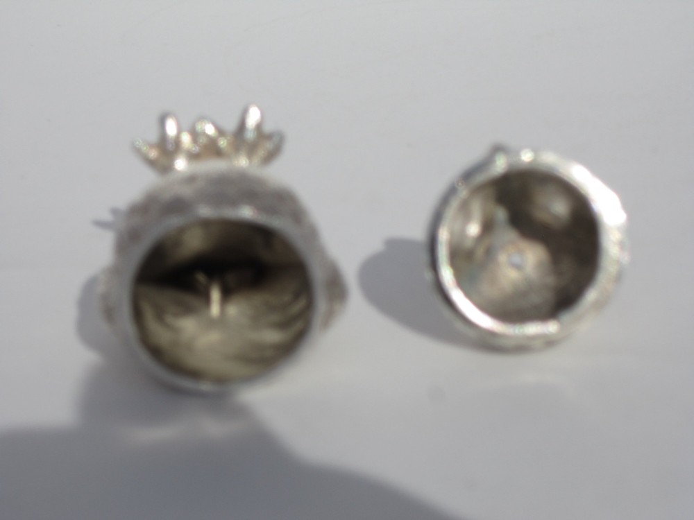 A pair of cast sterling silver salt and pepper shakers in the form of standing owls with textured feather detailing and dark amber glass eyes. View X