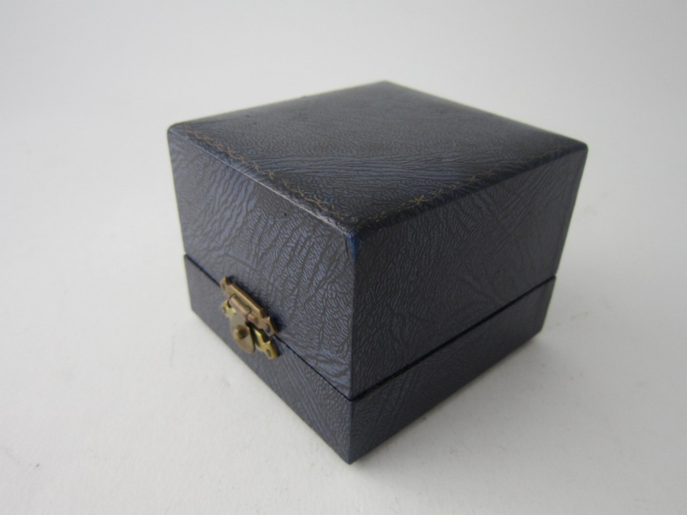 An octagonal sterling silver napkin ring with reeded borders presented inside a fitted blue velvet case. View II