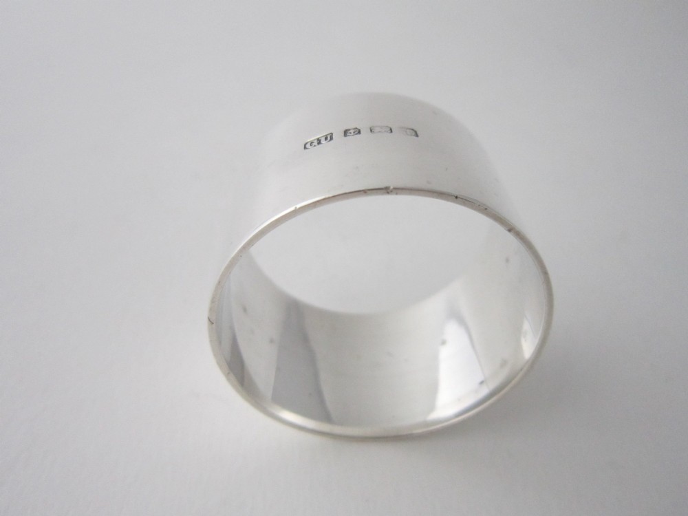 A plain cylindrical sterling silver napkin ring displaying a polished metallic finish. View III