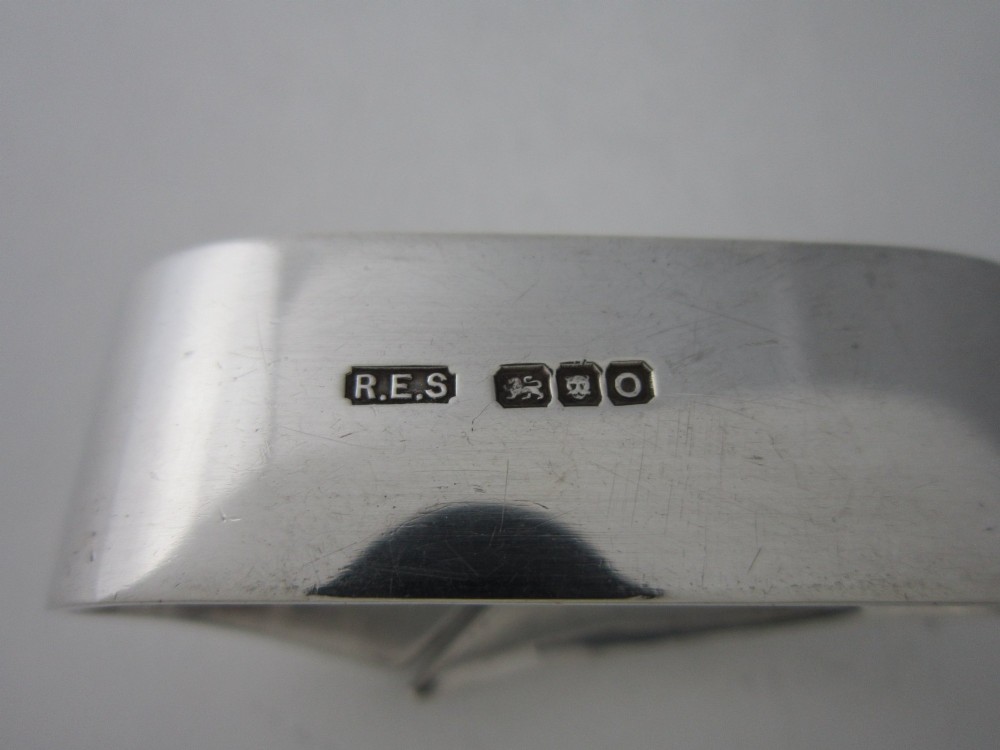 A sterling silver napkin ring crafted in 1949 with an asymmetrical geometric motif featuring grooved stepped lines. View VI