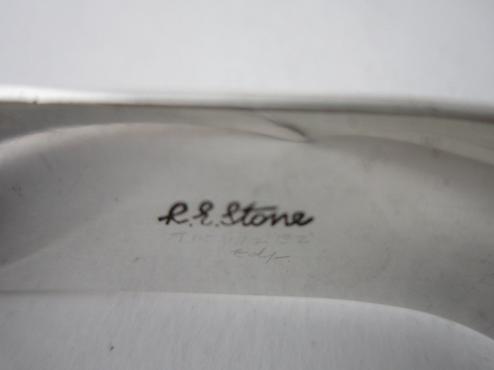 A sterling silver napkin ring crafted in 1949 with an asymmetrical geometric motif featuring grooved stepped lines. View VII