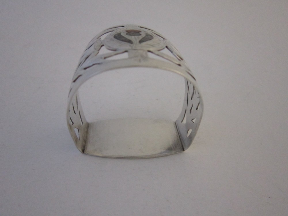 A pierced sterling silver napkin ring featuring engraved Scottish thistle motifs and a central inlaid agate stone. View II
