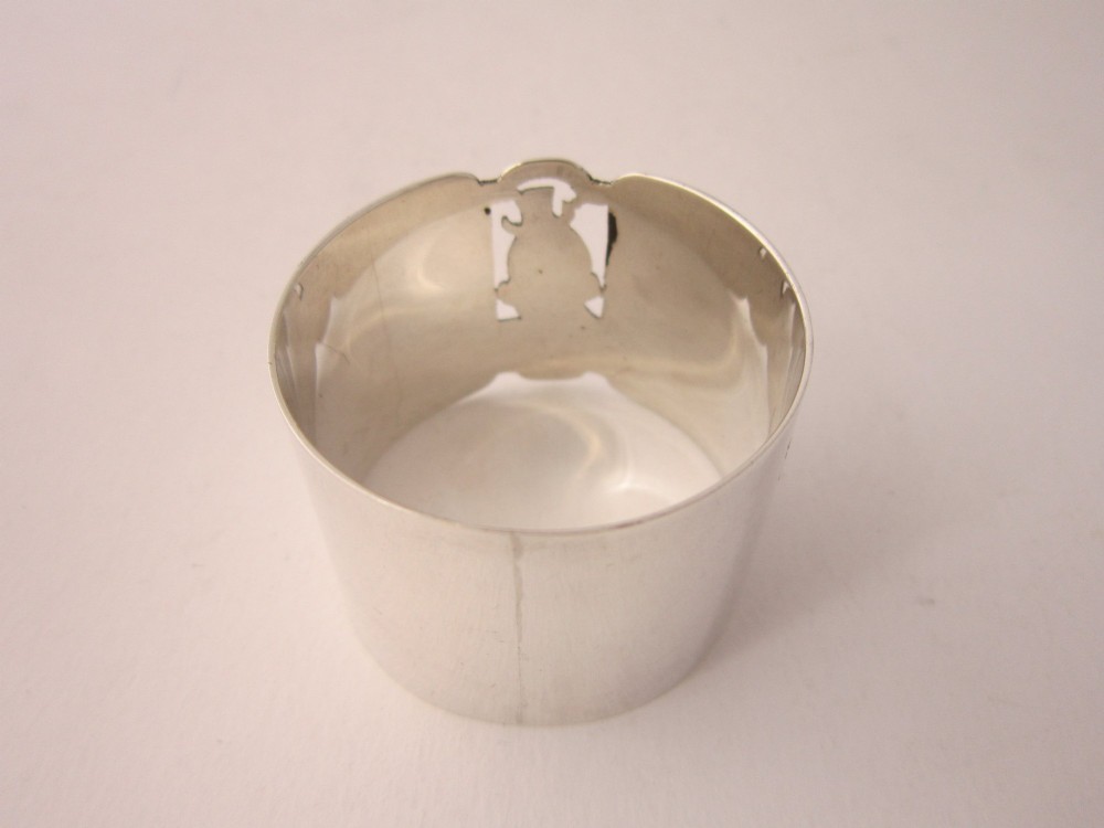 A sterling silver napkin ring featuring a pierced cutout motif of Humpty Dumpty wearing a top hat. View V