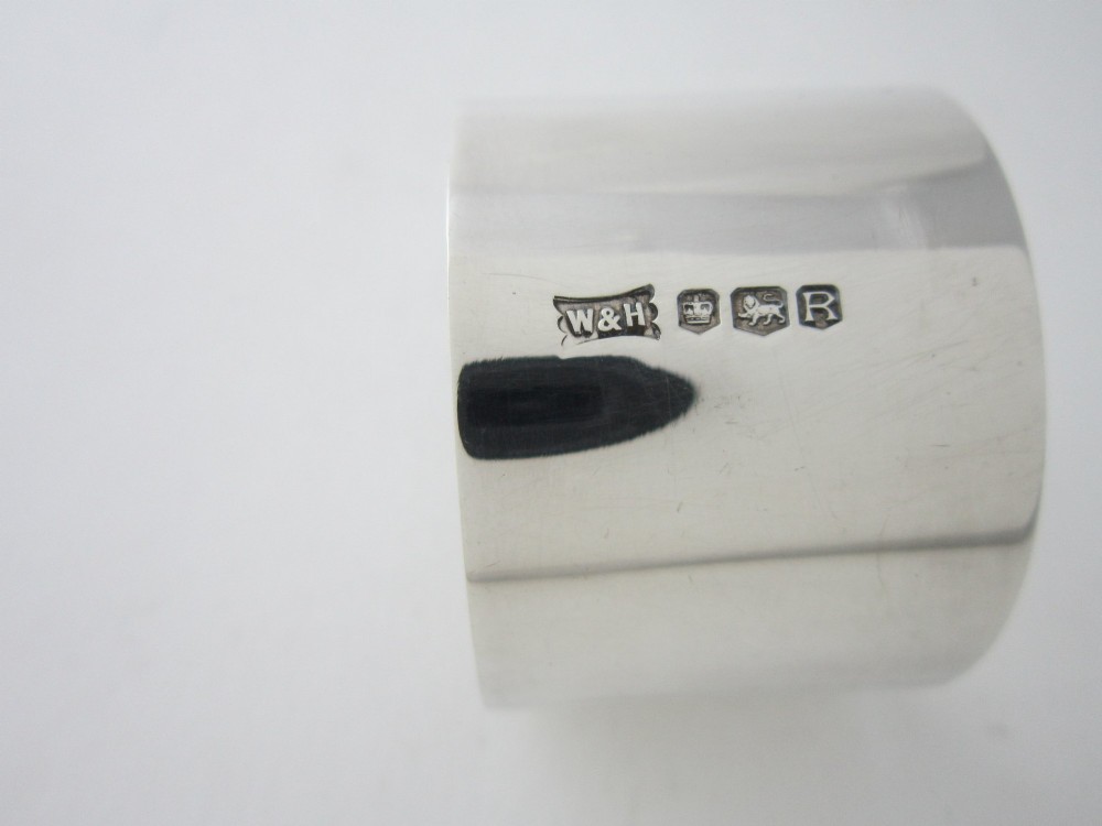 A sterling silver napkin ring featuring a pierced cutout motif of Humpty Dumpty wearing a top hat. View VII