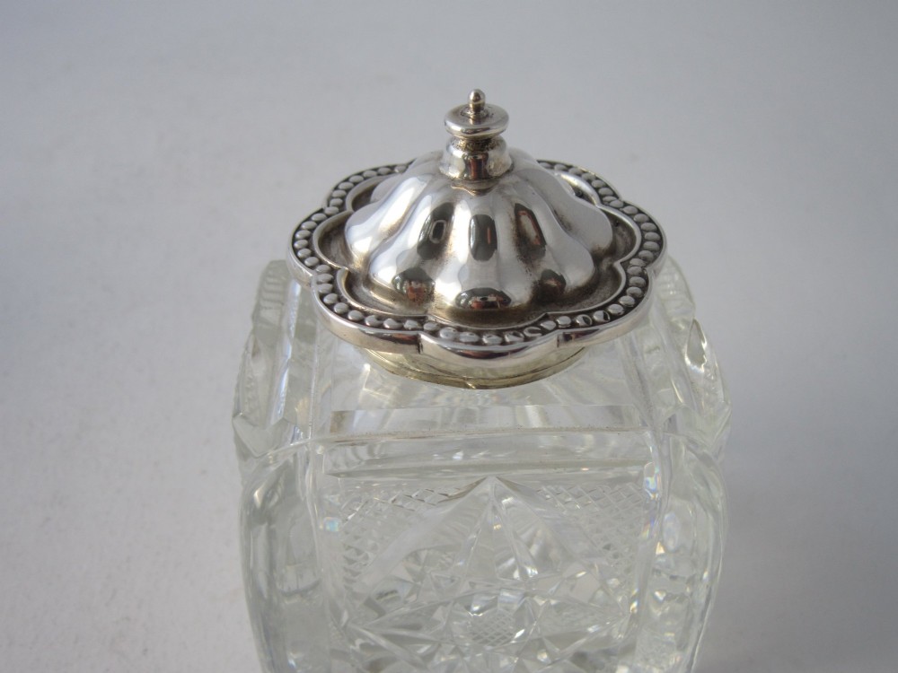 A George V sterling silver tray featuring a pierced gallery, scroll feet, a central pen recess, and two square cut-glass inkwells with silver lids. View X