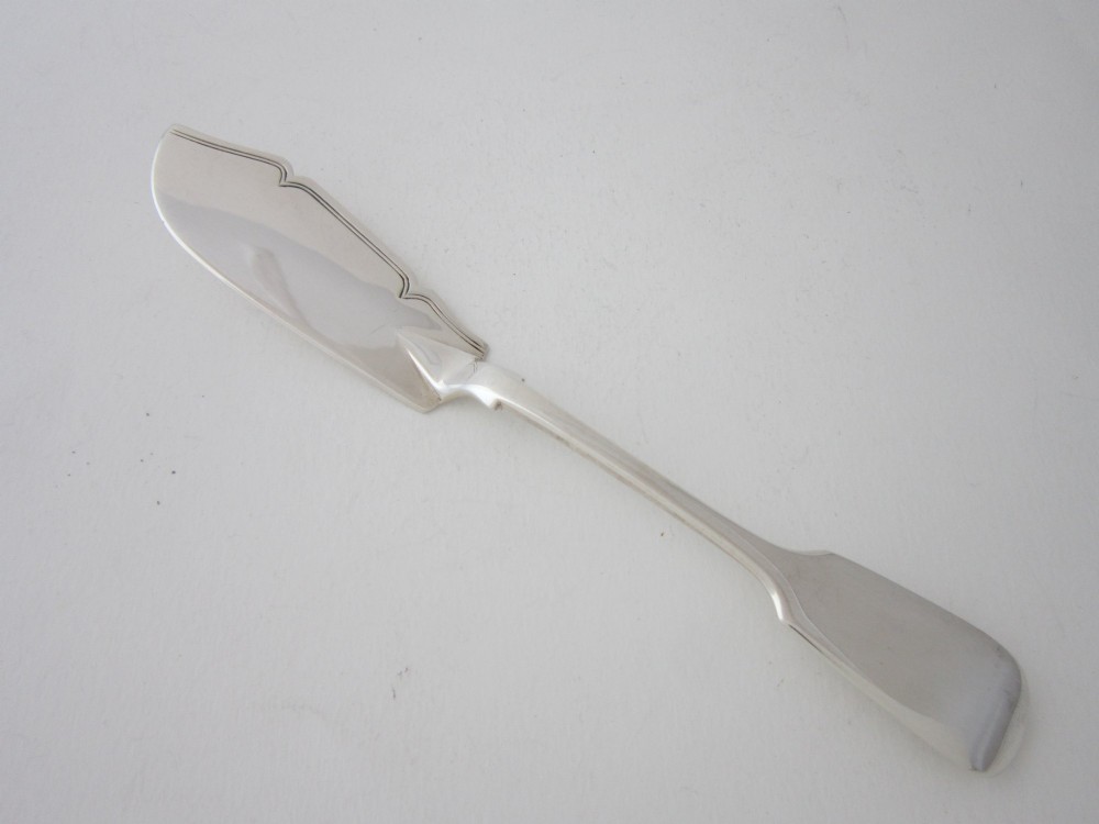 An antique Victorian sterling silver butter knife featuring a classic Fiddle pattern handle and a shaped spreading blade.