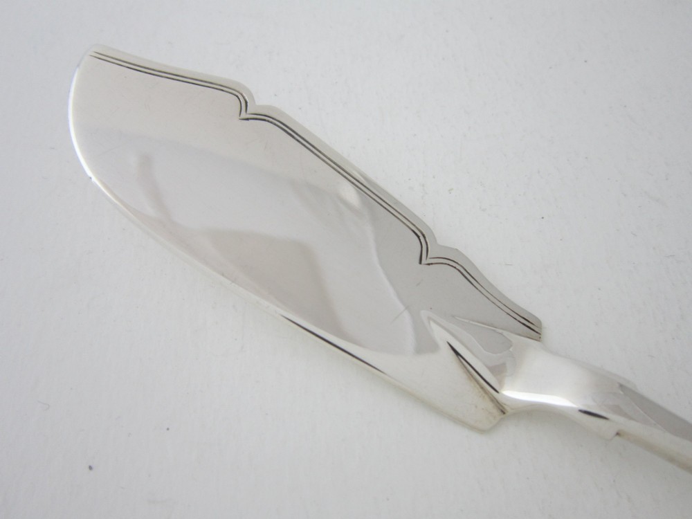 An antique Victorian sterling silver butter knife featuring a classic Fiddle pattern handle and a shaped spreading blade. View II