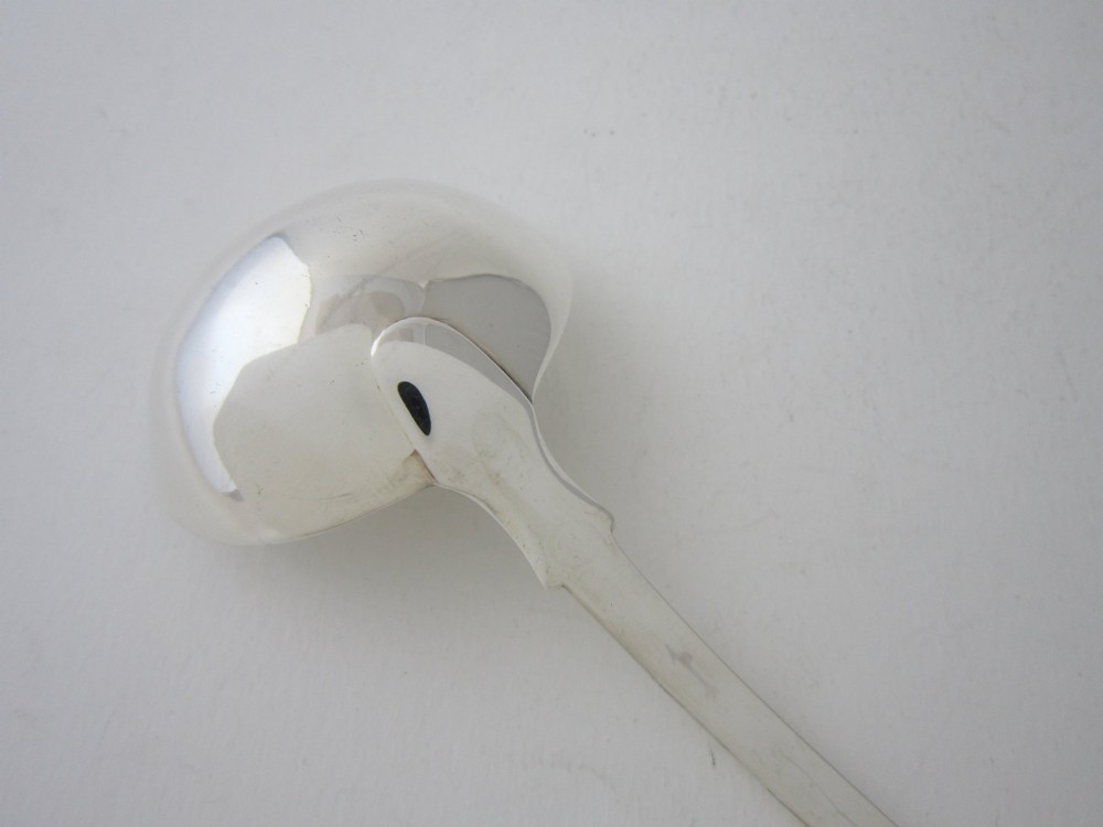 A Victorian sterling silver sauce ladle featuring a fiddle pattern handle and a round deep bowl, displayed on a plain white surface. View V