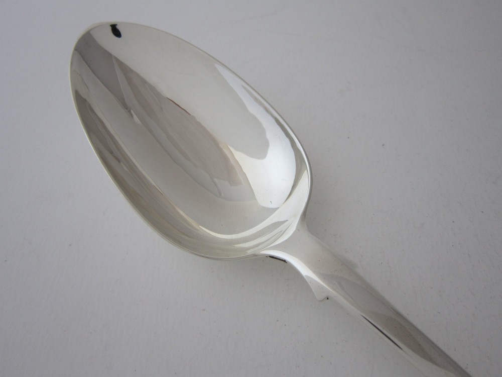 An antique Victorian sterling silver basting spoon featuring a classic fiddle pattern handle and a polished oval bowl. View II