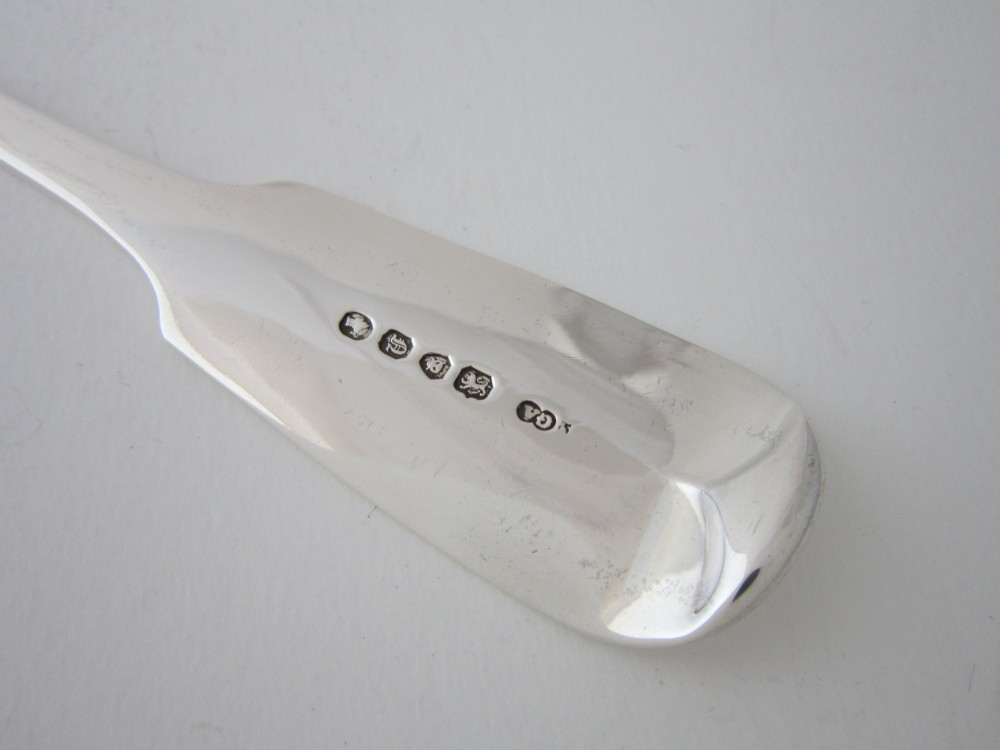 An antique Victorian sterling silver basting spoon featuring a classic fiddle pattern handle and a polished oval bowl. View VI