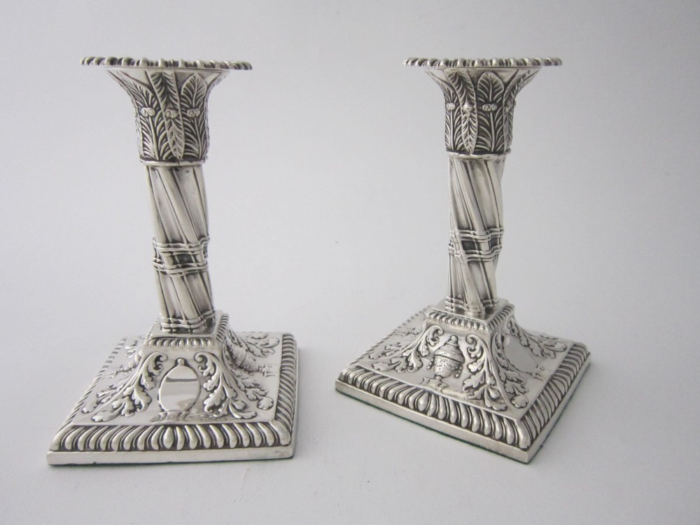 Pair of 1884 Victorian sterling silver candlesticks featuring spiral fluted column stems and square bases embossed with urn and leaf motifs. View III